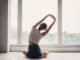 Persona esegue esercizi di stretching davanti a una finestra