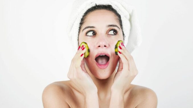 skin-care Persona con asciugamano in testa applica una maschera viso